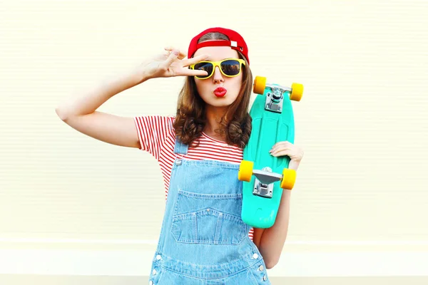 Ziemlich coole Frau mit Skateboard, die Spaß über weißem Hintergrund hat — Stockfoto