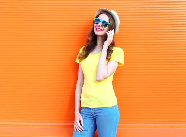 Mulher muito sorridente falando no smartphone sobre laranja colorido — Fotografia de Stock