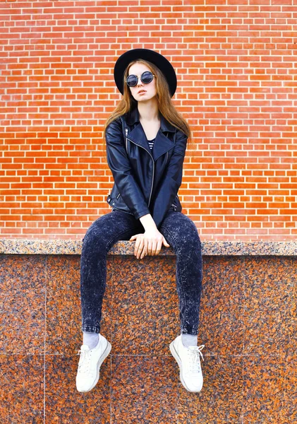 Mode ziemlich coole Frau im schwarzen Rock-Stil sitzt über Backstein — Stockfoto
