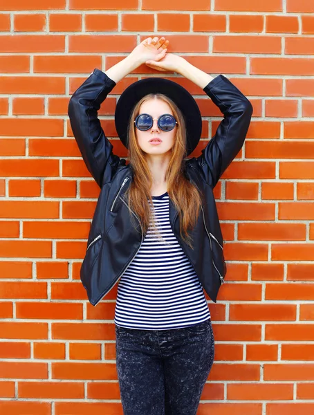 Modelo de mujer bonita de moda en estilo rock negro sobre ladrillos espalda — Foto de Stock