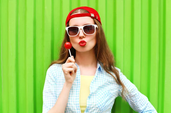 Модный портрет довольно крутой девушки с lollipop поверх зеленого бэкграунда — стоковое фото