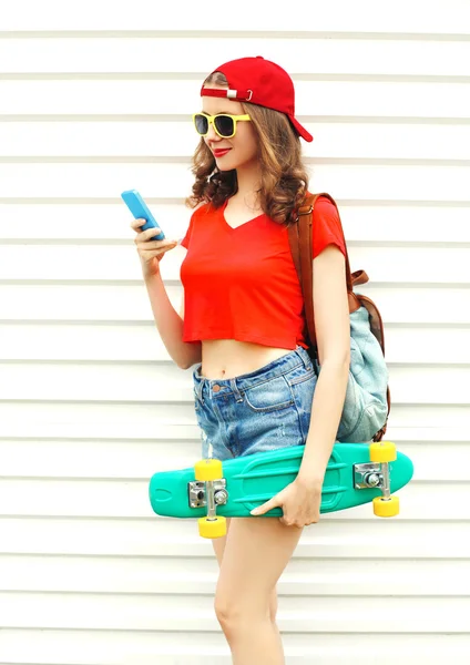 패션은 smartpho를 사용 하 여 스케이트 보드와 함께 꽤 멋진 웃는 여자 — 스톡 사진
