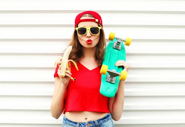 Moda donna piuttosto cool con skateboard e banana su bianco — Foto Stock