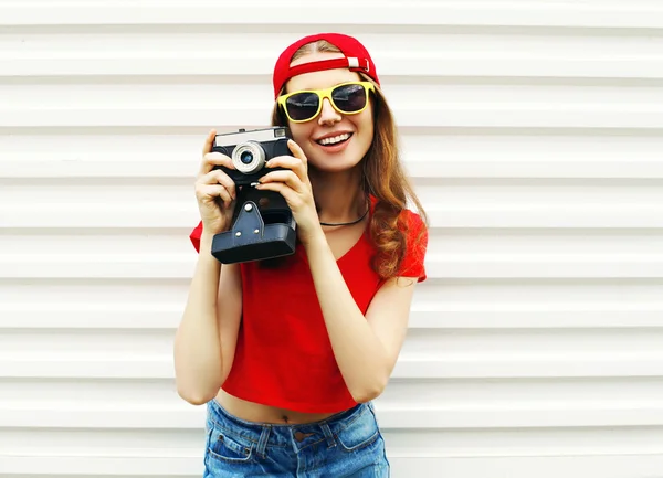 Модная симпатичная улыбчивая женщина с ретро-камерой, веселящаяся над W — стоковое фото