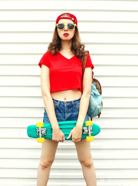 Moda bella donna con skateboard in occhiali da sole sopra ba bianco — Foto Stock
