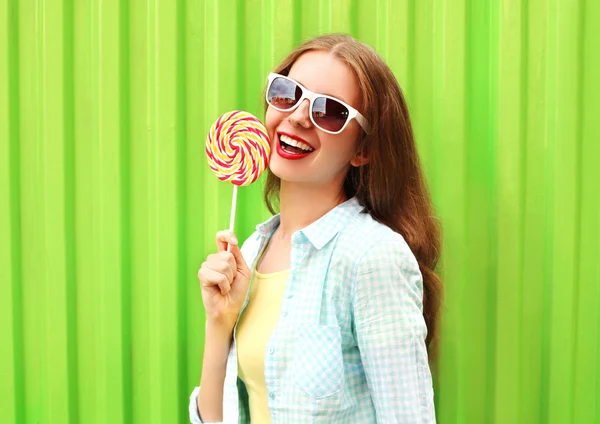 Retrato feliz mulher muito sorridente com pirulito sobre colorido — Fotografia de Stock
