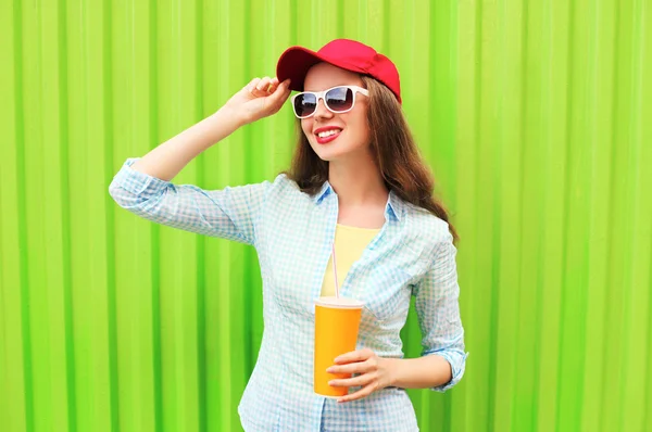 Hübsche lächelnde Frau mit Sonnenbrille und einer Tasse Fruchtsaft — Stockfoto