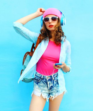 Kadın moda smartphone ov kullanarak kulaklık müzik dinler