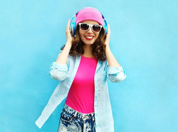 Fashion pretty cool smiling woman listens to music in headphones — Stock Photo, Image