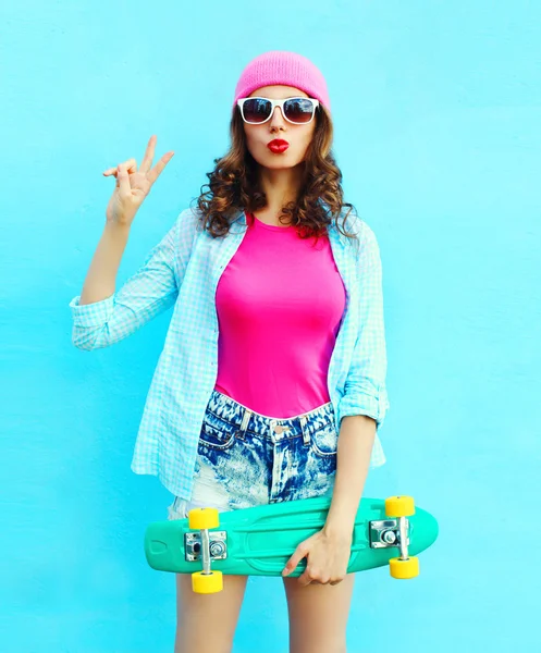 Moda bella donna cool in rosa con skateboard su colorato — Foto Stock