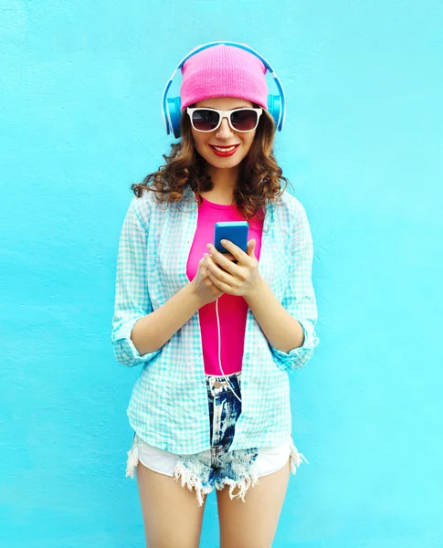 Piuttosto cool donna ascolta musica in cuffia utilizzando smartphon — Foto Stock