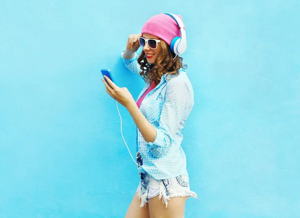 Mulher bonita ouve música em fones de ouvido usando ove smartphone — Fotografia de Stock