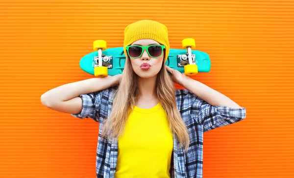 Mode ziemlich cooles Mädchen mit Skateboard über bunte orange ba — Stockfoto