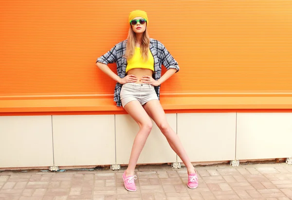 Модная симпатичная девушка-модель позирует на цветном оранжевом фоне — стоковое фото