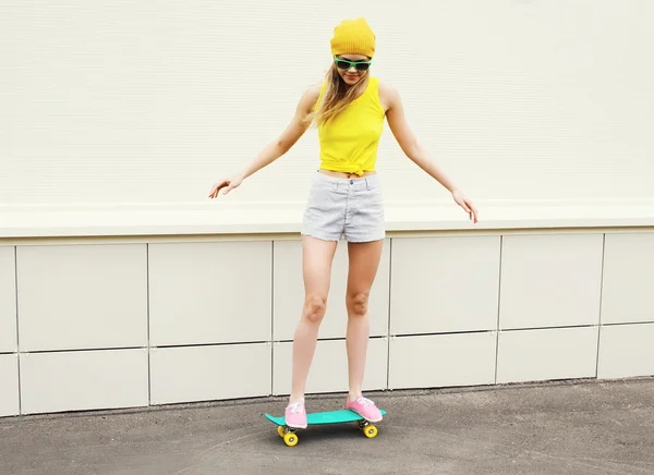 Mode jolie fille chevauchant sur skateboard en ville sur fond blanc — Photo