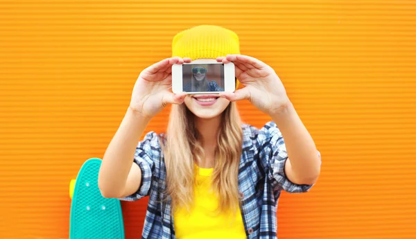 Mujer rubia bonita hace autorretrato en el teléfono inteligente sobre el color — Foto de Stock