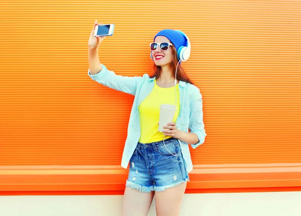 Модная симпатичная девушка делает автопортрет на смартфоне — стоковое фото