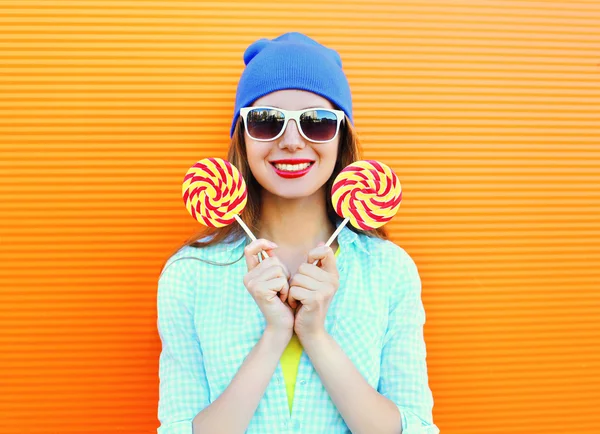 Portrait happy pretty smiling woman and lollipop over colorful o — Stock Photo, Image
