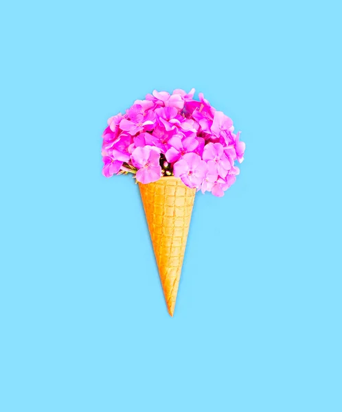 Конус морозива з квітами над синім тлом зверху — стокове фото