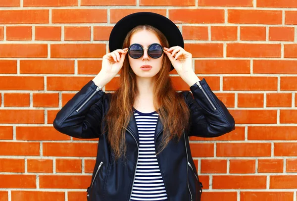 Fashion portrait pretty woman in black rock style posing over br — Stock Photo, Image