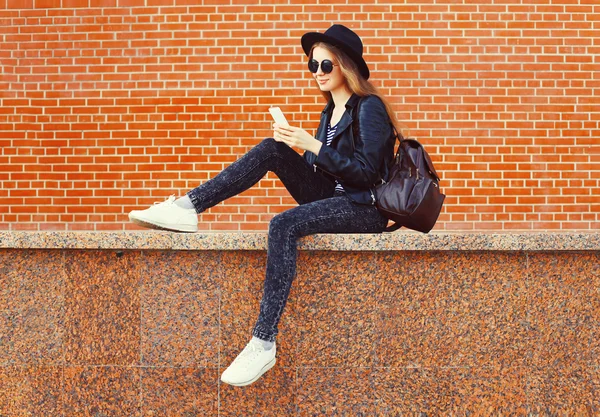 Модная симпатичная женщина с помощью смартфона в стиле рок-н-ролла над б — стоковое фото
