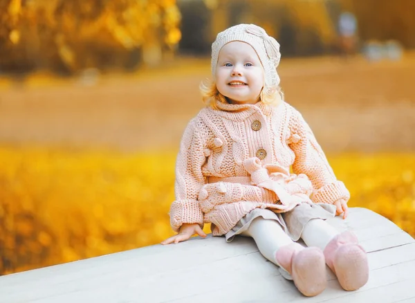 Portre sevimli gülümseyen çocuk sıcak güneşli autum açık havada oturan — Stok fotoğraf