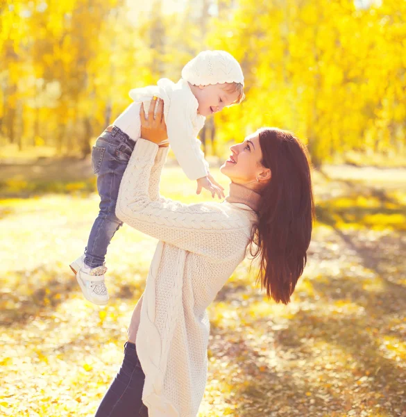 Feliz madre sonriente jugando con el niño divirtiéndose en el cálido sol —  Fotos de Stock