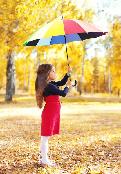 Little girl child with colorful umbrella in sunny autumn day loo — Stock Photo, Image