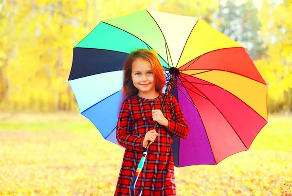 Güneşli renkli şemsiye ile mutlu gülümseyen küçük kız çocuk — Stok fotoğraf