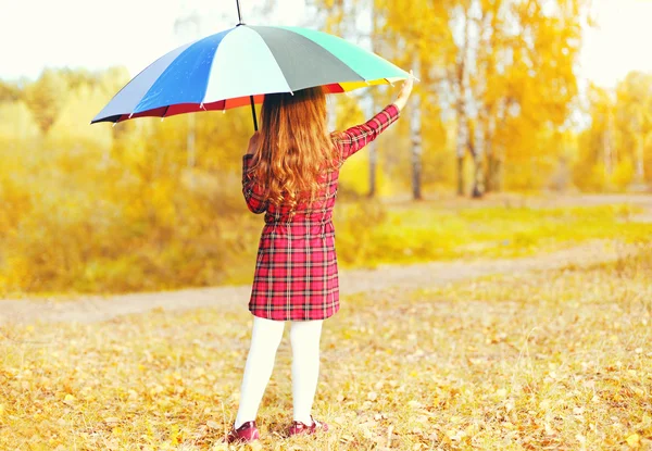 Little girl child with colorful umbrella over sunny autumn backg — Stock Photo, Image