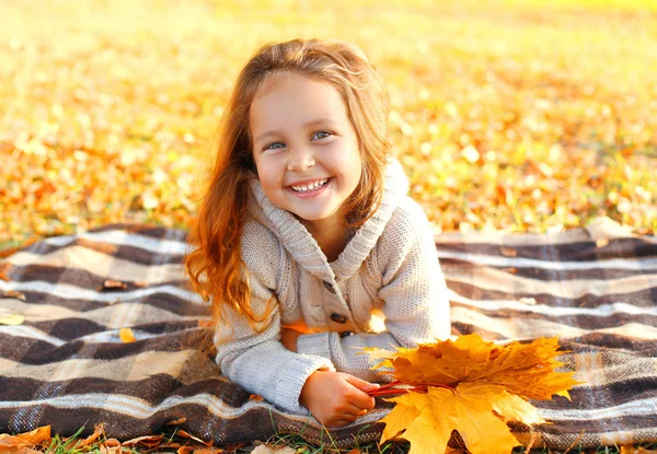 Portrait happy smiling child lying having fun with yellow maple — Stock Photo, Image