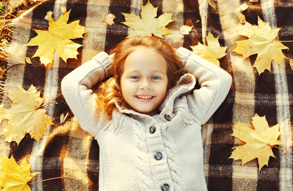 Retrato feliz niño sonriente acostado divirtiéndose con arce amarillo — Foto de Stock