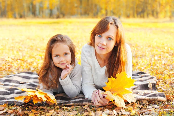 Portrait mère et enfant avec des feuilles d'érable jaune couchées — Photo