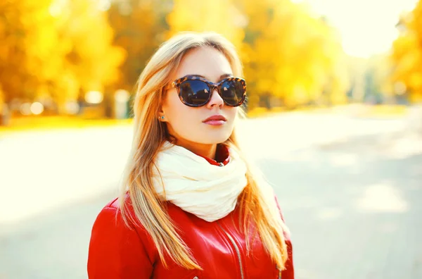 Mulher loira bonita vestindo um óculos de sol e casaco vermelho com — Fotografia de Stock