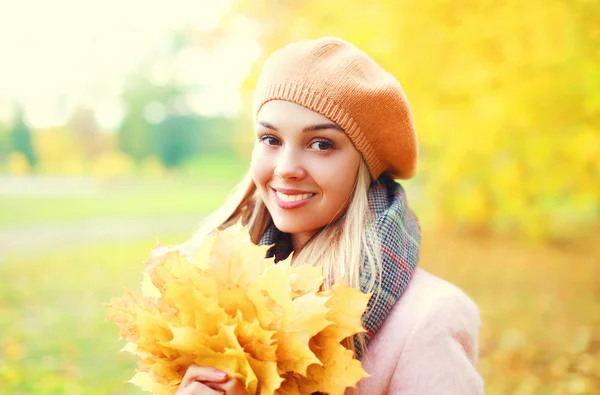 Portrait belle femme souriante aux feuilles d'érable jaunes au chaud — Photo