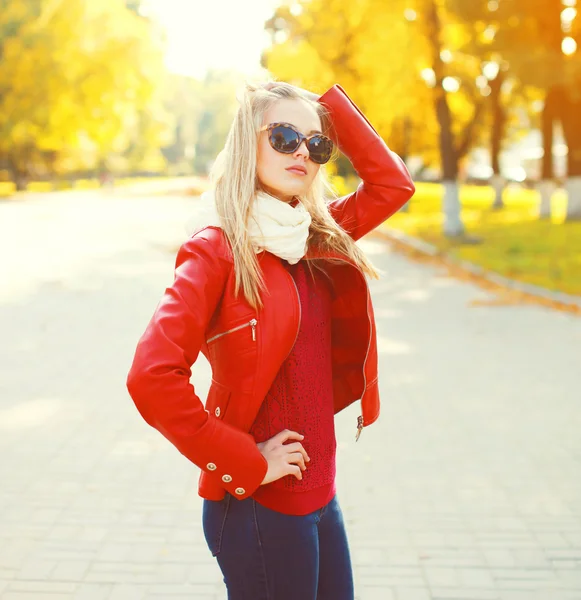 Mulher loira bonita vestindo um óculos de sol e casaco vermelho com sca — Fotografia de Stock