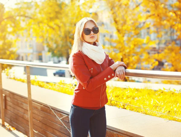 Mulher loira bonita usando óculos de sol e casaco vermelho com cachecol — Fotografia de Stock