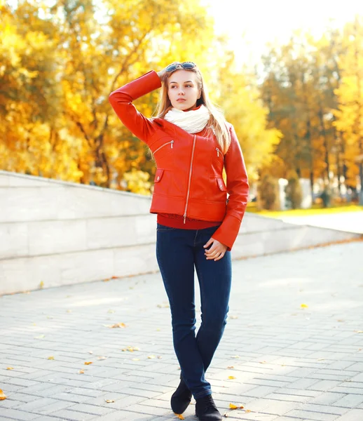 Hübsche junge Frau in roter Jacke an einem sonnigen Herbsttag — Stockfoto