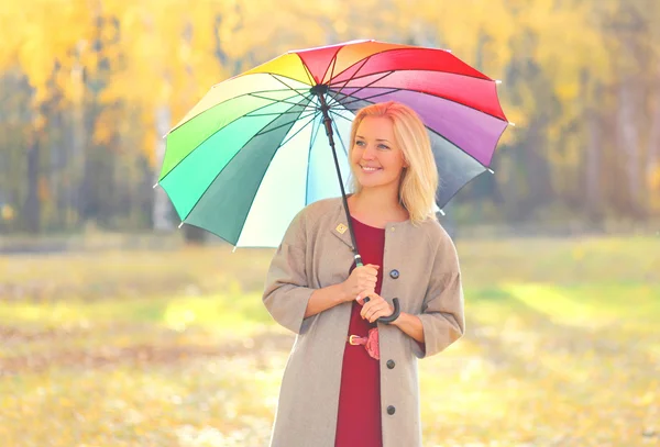 Portrait of beautiful smiling woman with colorful umbrella in wa — Stock Photo, Image