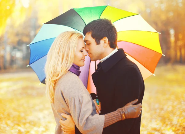 Portrait of romantic kissing couple in love with colorful umbrel — Stock Photo, Image