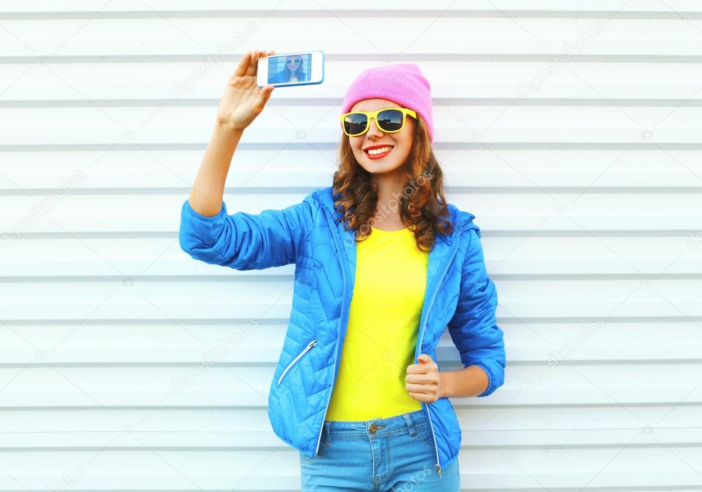 Fashion happy cool smiling girl in colorful clothes taking pictu