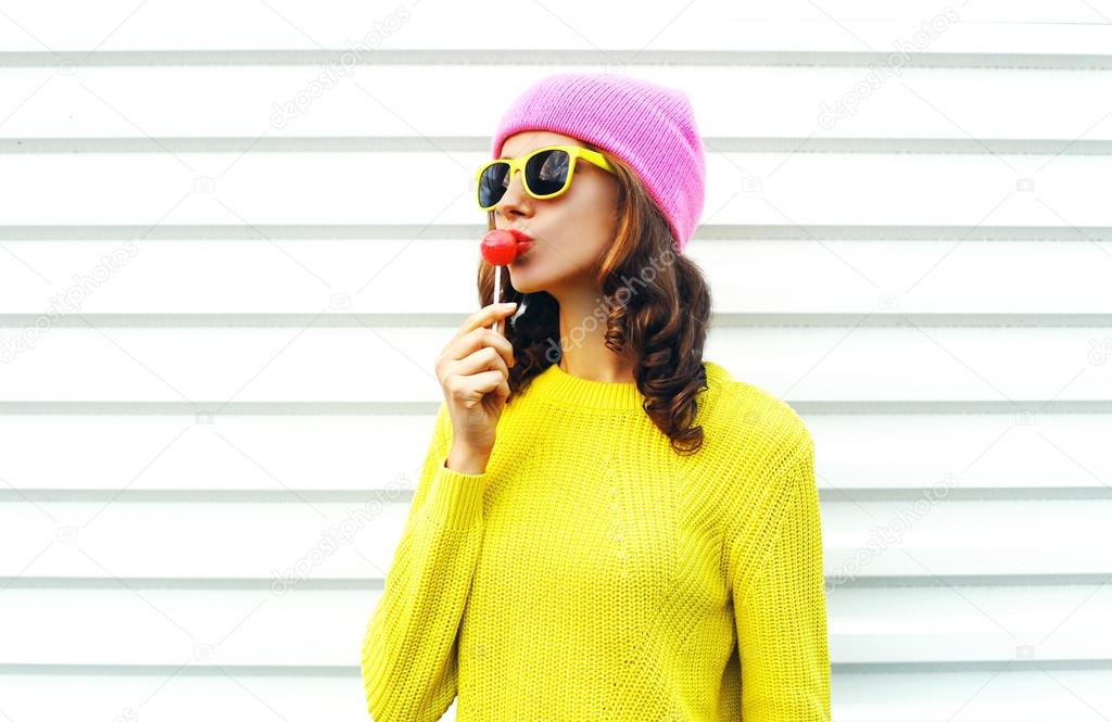 Portrait fashion pretty cool girl sucking lollipop in colorful c