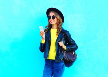 Siyah bir kaya giyen akıllı telefon kullanarak Moda güzel genç kadın