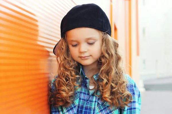 城市里戴棒球帽的小女孩的画像 — 图库照片