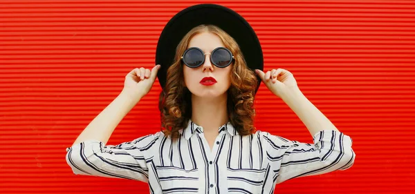 黒丸の帽子をかぶった魅力的な女性の肖像と赤い背景に縞模様の白いシャツ — ストック写真