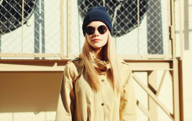 Arka planda şehirde poz veren zarif sarışın kadın modeli.