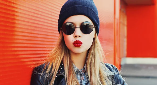 黒のロックスタイルの服を着て赤い唇を吹いてスタイリッシュな美しい若い女性の肖像画 — ストック写真