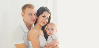 Mutlu bir ailenin portresi, anne ve baba ve bebek evi pencerenin yanındaki beyaz odada.