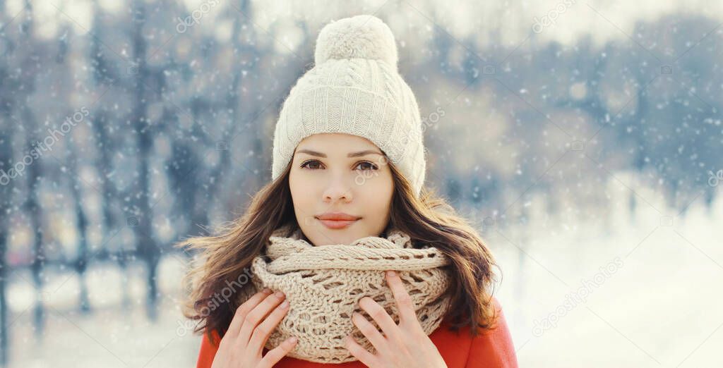 Portrait of lovely young brunette woman wearing a red jacket, scarf in winter