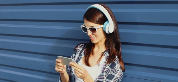 Портрет Молодої Жінки Бездротових Навушниках Телефоном Слухає Музику Синьому Фоні — стокове фото